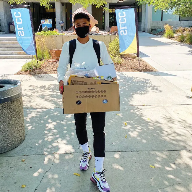 大学のフードパントリーで受け取った食材を運ぶ沖吉大夢選手